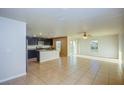 Bright open-plan living area with tile flooring, a ceiling fan, and sliding glass doors to the backyard at 1147 Moyle Way, Mascotte, FL 34753