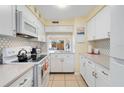 Bright kitchen featuring white cabinets, updated countertops, and modern appliances at 120 Georgetown Dr, Casselberry, FL 32707