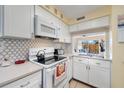 Bright kitchen featuring white cabinets, updated countertops, and modern appliances at 120 Georgetown Dr, Casselberry, FL 32707