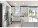 White kitchen with stainless steel appliances and quartz countertops at 15813 Gem View St, Winter Garden, FL 34787