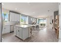 Open concept kitchen with white cabinets, island, and stainless steel appliances at 15813 Gem View St, Winter Garden, FL 34787
