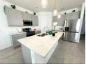 Modern kitchen with gray cabinets, stainless steel appliances, and a large island at 2058 Derwent Dr, Davenport, FL 33896