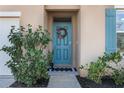 Inviting home exterior with teal front door, landscaping, and walkway at 2128 Silver Brook Way, Davenport, FL 33837