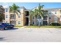 Building entrance with parking and landscaping at 2300 Butterfly Palm Way # 205, Kissimmee, FL 34747