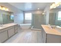 Spa-like bathroom with dual vanities, soaking tub, and a frameless glass shower at 2678 Great Heron Ave, St Cloud, FL 34773