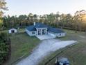 Aerial view of a house with a three-car garage, large yard, and outbuildings at 720 Napoli Ln, New Smyrna Beach, FL 32168