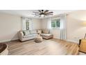 Light and airy living room featuring a sectional sofa and wood-look floors at 1260 Lake Helen Osteen Rd, Lake Helen, FL 32744