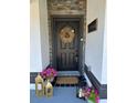 Close up view of a decorated front door with wreath, lanterns, fresh pink flowers, and attractive accents at 1490 11Th Ave, Deland, FL 32724