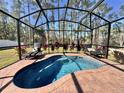 Screened-in pool featuring lounge chairs and beautiful brick surround provides a relaxing outdoor oasis at 1490 11Th Ave, Deland, FL 32724