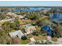 An aerial view showcases the home, pool, and surrounding landscape near the lake at 1715 Concert Rd, Deltona, FL 32738