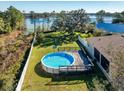 Round above ground pool with a wooden deck overlooking the lake at 1715 Concert Rd, Deltona, FL 32738