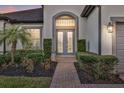 Elegant entryway with double doors and meticulously landscaped surroundings at 1954 Filly Trl, Oviedo, FL 32765