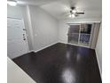 Living room with dark laminate floors, sliding glass doors to a balcony, and a ceiling fan at 1979 Summer Club Dr # 309, Oviedo, FL 32765