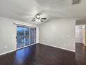 Living room with dark laminate floors, sliding glass doors to a balcony, and a ceiling fan at 1979 Summer Club Dr # 309, Oviedo, FL 32765