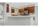 Spacious kitchen with dark wood cabinetry, stainless steel appliances, and a breakfast bar at 2555 Sand Arbor Cir, Orlando, FL 32824