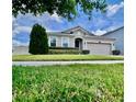 Charming home with a manicured lawn and landscaping, complemented by a brick paver driveway and two-car garage at 3333 Wauseon Dr, St Cloud, FL 34772