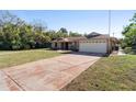 Front view of charming ranch home with driveway and mature trees at 43 Dahlia Dr, Debary, FL 32713