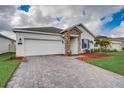 Curb appeal with a landscaped yard and paver driveway at 6324 Chirpine Ln, Saint Cloud, FL 34771