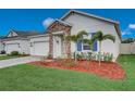 Landscaped yard with palm trees and a white exterior at 6324 Chirpine Ln, Saint Cloud, FL 34771