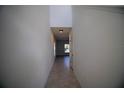 Long hallway with tiled flooring and neutral walls at 1053 Waterfall Blvd, Davenport, FL 33837