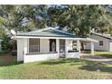 White bungalow home with a green metal roof and carport at 122 Magnolia Dr, Winter Haven, FL 33881