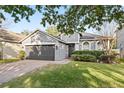 Gray house with 2-car garage, manicured lawn, and brick driveway at 1449 Ashdown Ct, Sanford, FL 32771