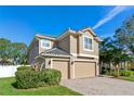 Two-story house with a three-car garage and lush landscaping at 148 Calliope St, Ocoee, FL 34761