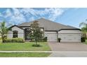 Exterior view of a single-Gathering home with a three-car garage and landscaping at 17608 Sailfin Dr, Orlando, FL 32820