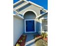 Blue front door with a walkway and landscaping at 2413 Rock Ct, Poinciana, FL 34759