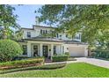 Two-story white house with a brick walkway, lush landscaping, and a two-car garage at 3513 Pinetree Rd, Orlando, FL 32804