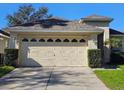 Tan house with beige garage door and manicured lawn at 5119 Santa Ana Dr, Orlando, FL 32837