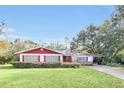 Red and white ranch house with a well-maintained lawn at 5217 N Apopka Vineland Rd, Orlando, FL 32818