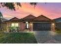 Charming one-story house with a dark brown garage door, and nice landscaping at 7927 Oakstone Ct, Orlando, FL 32822