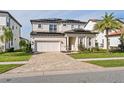 Two-story house with solar panels, a three-car garage, and a manicured lawn at 10631 Royal Cypress Way, Orlando, FL 32836