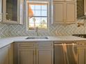 Modern kitchen with gray cabinets, marble countertops, and a stainless steel sink at 13305 Lacebark Pine Rd, Orlando, FL 32832