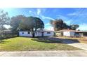 Back view of a white single story home with a large yard at 1416 Wilton Ave, Orlando, FL 32805