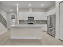 Modern kitchen with white cabinets, stainless steel appliances, and quartz countertops at 1479 Brookdale Ct, Oviedo, FL 32765