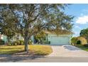 Light green house with a paved driveway and large oak tree at 300 Sorrento Rd, Poinciana, FL 34759