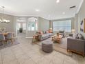 Bright living room with gray sofas, wood coffee table, and tile floors at 4957 Rock Rose Loop, Sanford, FL 32771