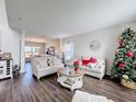 Living room with hardwood floors, comfortable seating, and a view into the dining area at 5417 Calla Lily Ct, Kissimmee, FL 34758