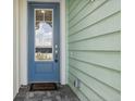 Blue front door with a glass panel and welcome mat at 597 Lost Shaker Way, Daytona Beach, FL 32124