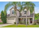 Two-story house with gray siding, beige garage door, and palm trees at 605 Brightview Dr, Lake Mary, FL 32746