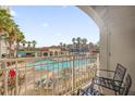 Relaxing balcony view overlooking a community pool with palm trees and lounge chairs at 7383 Universal Blvd # 207, Orlando, FL 32819