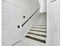 Modern white and grey staircase with dark metal railing at 7615 Bay Port Rd # 36, Orlando, FL 32819