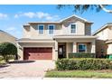 Two story house with a red door and attached garage at 7654 Wilmington Loop, Kissimmee, FL 34747