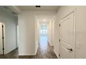 Bright hallway with wood-look flooring and neutral walls at 807 Ofanto Way, Haines City, FL 33844