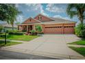 Charming one-story house featuring a three-car garage and lush landscaping at 169 Magneta Loop, Auburndale, FL 33823