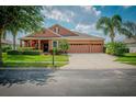 Attractive one-story home with three-car garage and manicured lawn at 169 Magneta Loop, Auburndale, FL 33823