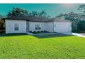 Newly built home showcasing a large front yard and a two-car garage at 227 W 4Th St, Chuluota, FL 32766