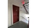 Red door entry to condo unit with nearby staircase at 11538 Westwood Blvd # 226, Orlando, FL 32821